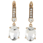 Pair of gold earrings with clear gemstones on a white background