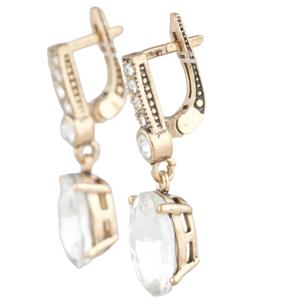 Gold earrings with clear gemstones on a white background