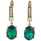 Gold earrings with green gemstones on a white background