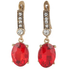 Gold earrings with red gemstones on a white background
