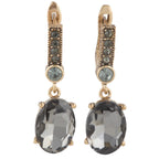 Gold earrings with dark gemstones on a white background