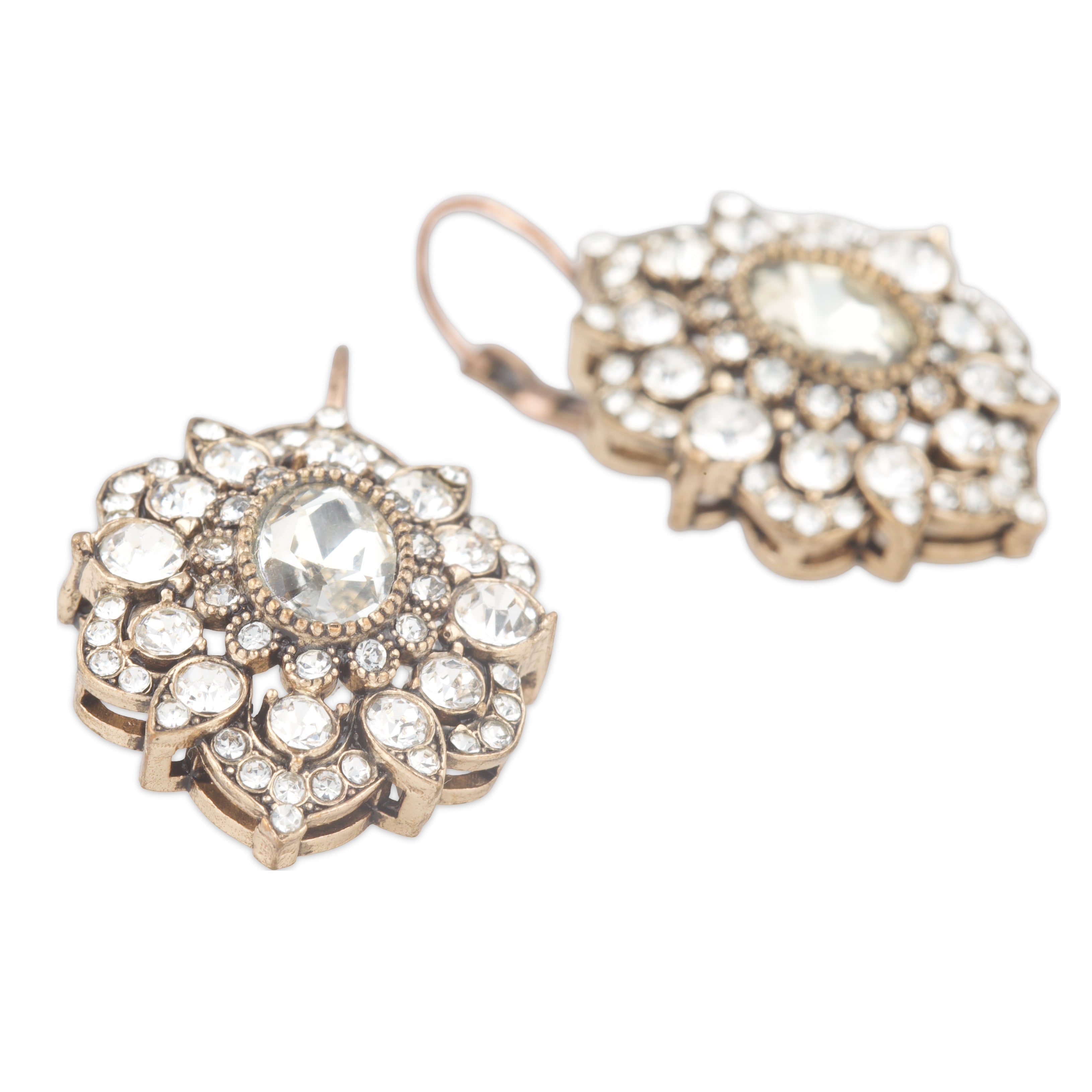 Pair of ornate earrings with clear gemstones on a white background