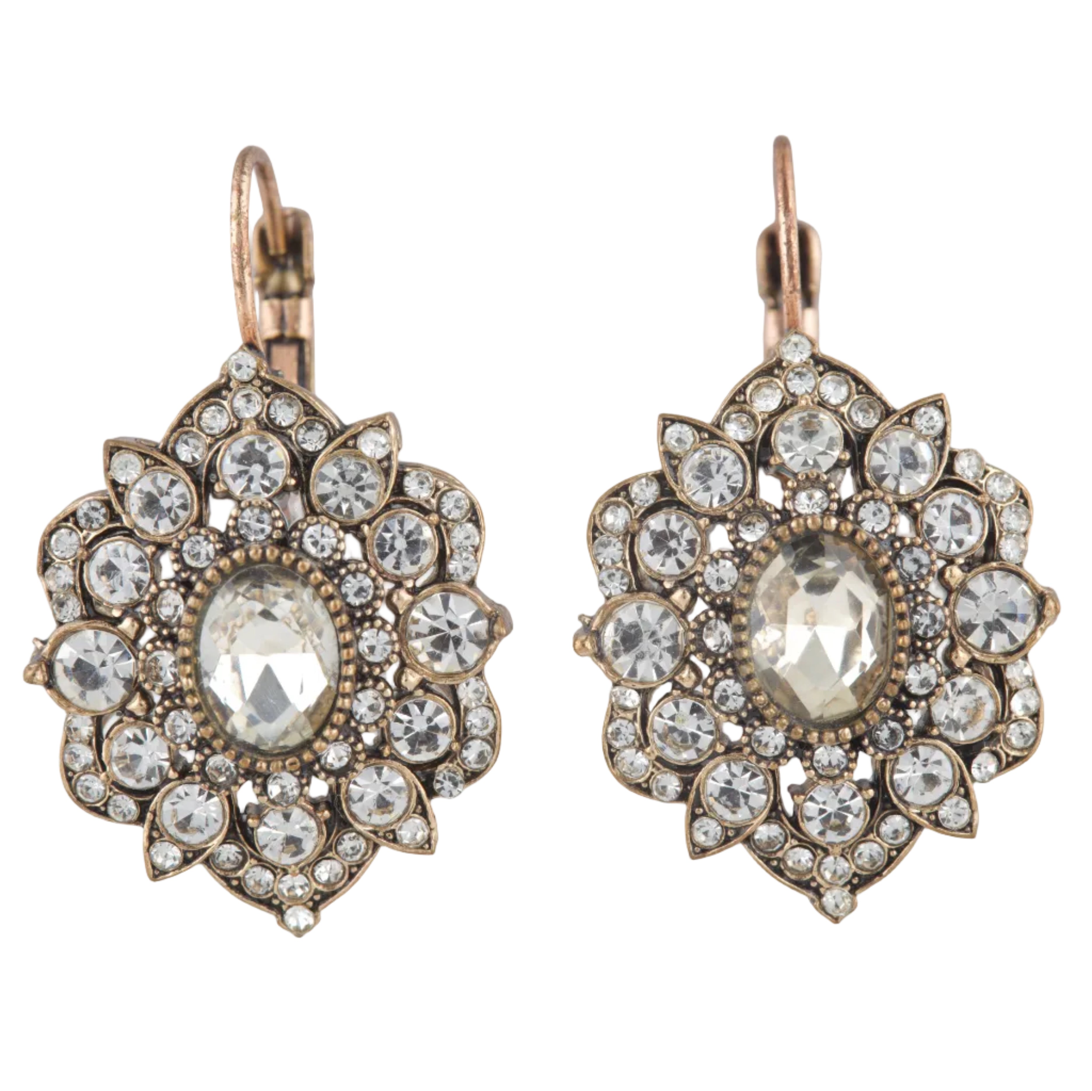 Pair of ornate earrings with clear gemstones on a white background