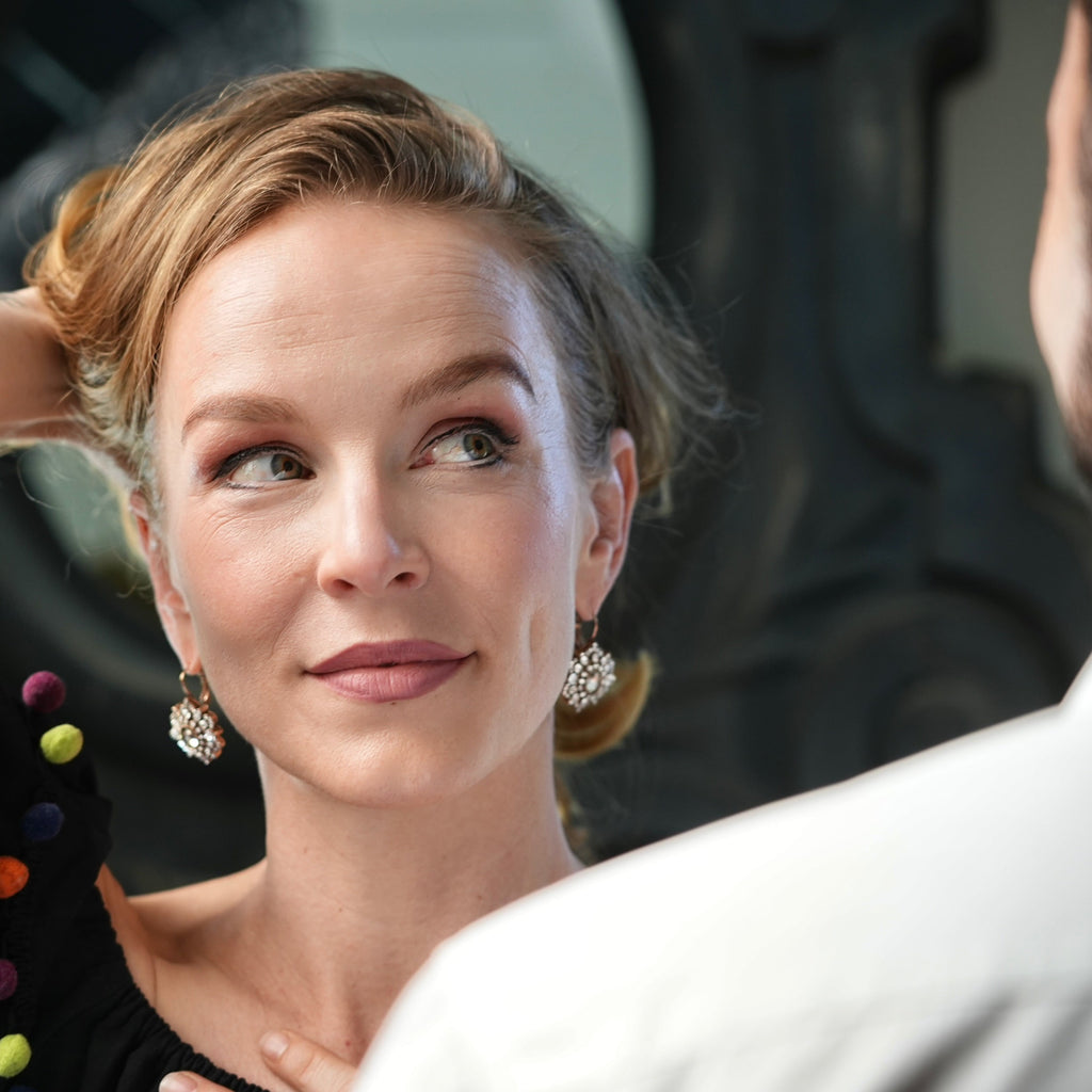 Woman adjusting her hair in a mirror with a blurred background