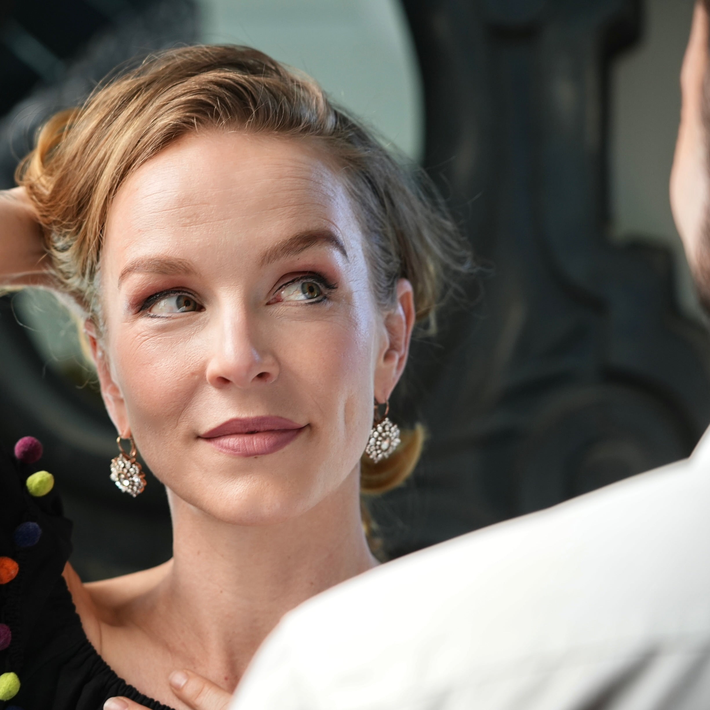 Woman adjusting her hair in a mirror with a blurred background