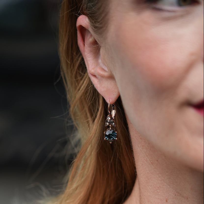 Close-up of a woman wearing a pair of earrings with a blurred background