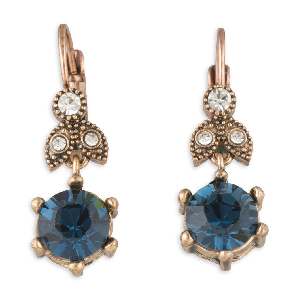 Pair of earrings with blue gemstones and rose gold accents on a white background
