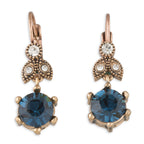 Pair of earrings with blue gemstones and rose gold accents on a white background
