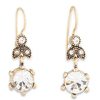 Gold and crystal drop earrings on a white background