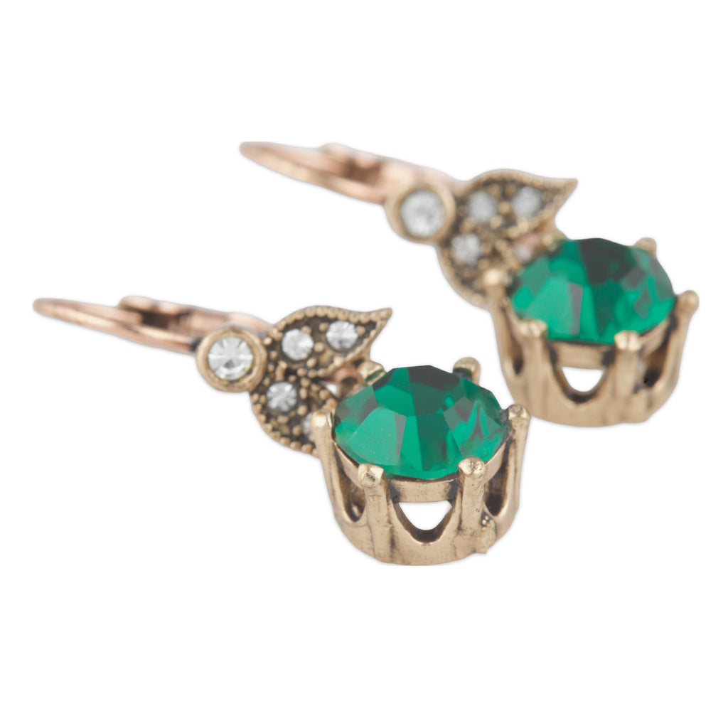 Gold earrings with green gemstones on a white background