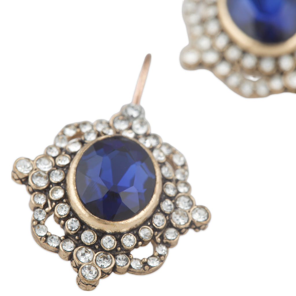 Earrings with blue gemstones and gold accents on a white background