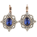 Pair of earrings with blue gemstones and gold accents on a white background