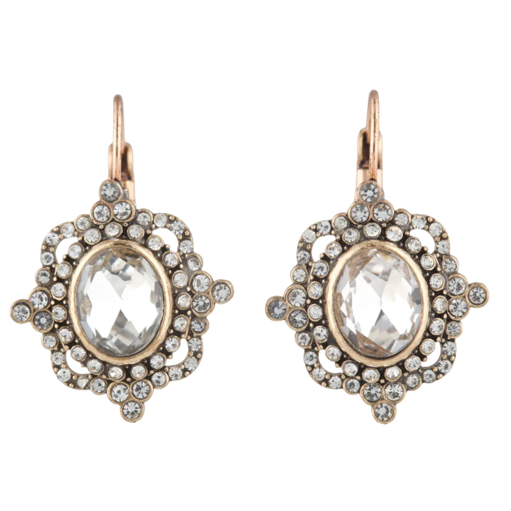 Pair of ornate earrings with clear gemstones and gold accents on a white background