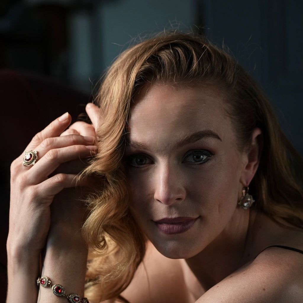 Close-up of a woman wearing a decorative earring with a clear gemstone against a blurred background