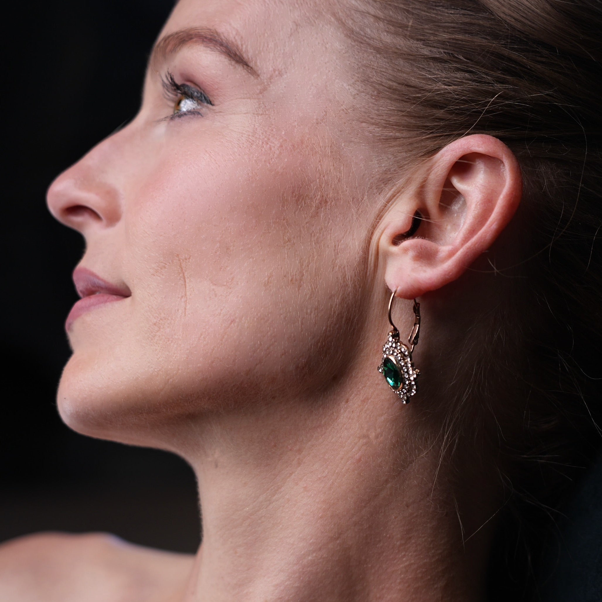 Close-up of a woman wearing an earring with a dark background