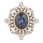 Jewelry item with blue gemstone and gold frame on a white background