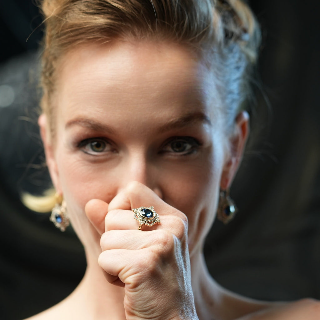 Woman with a ring on her finger holding a white string against a dark background