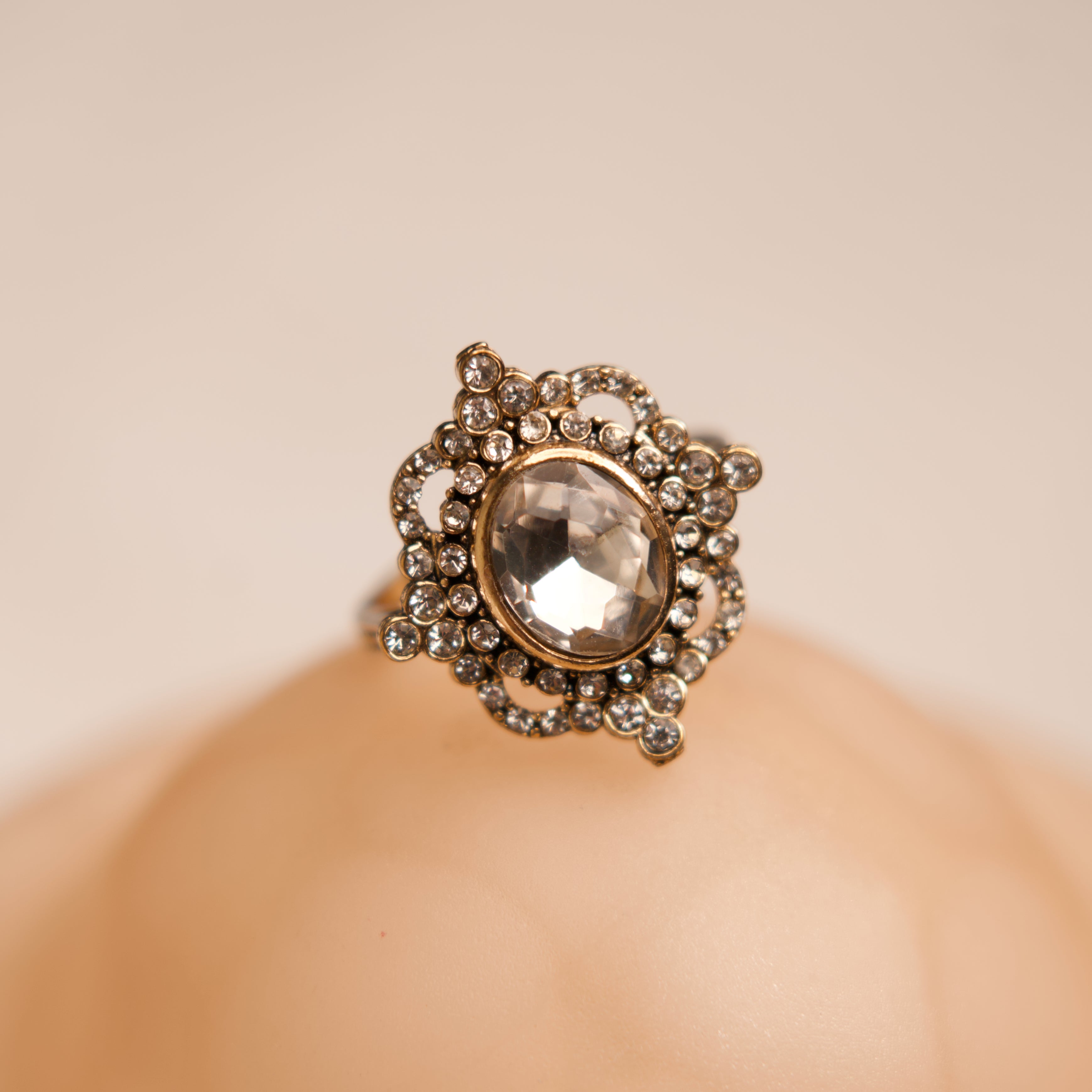 Decorative ring with a central gemstone on a beige background