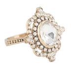 Gold ring with a large central gemstone and smaller stones on a white background