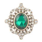 Gold ring with a green gemstone and clear stones on a white background