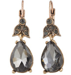 Pair of earrings with teardrop-shaped gemstones and leaf-like designs on a white background
