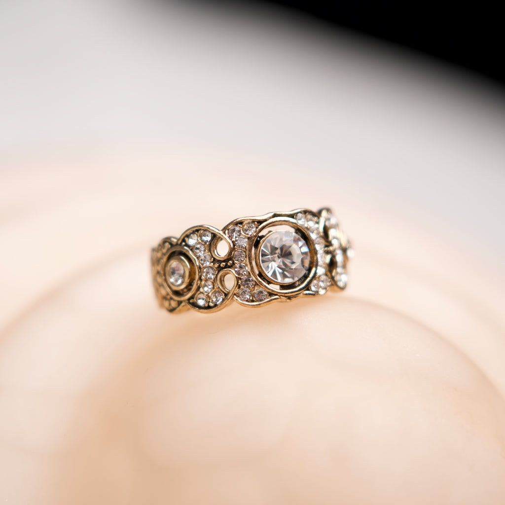 Gold ring with diamonds on a soft focus background