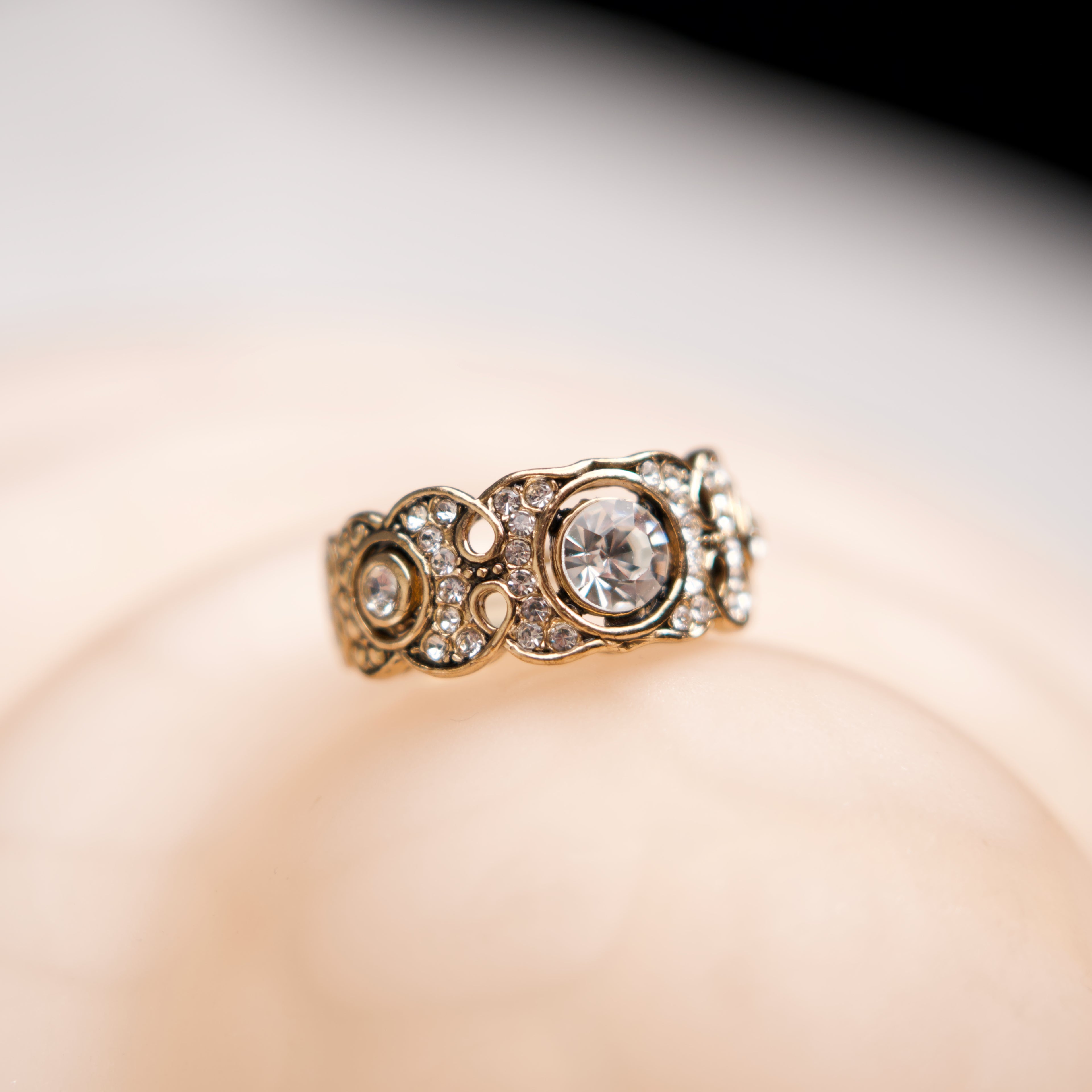 Gold ring with diamonds on a soft focus background