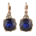 Pair of earrings with blue gemstones and rose gold accents on a white background