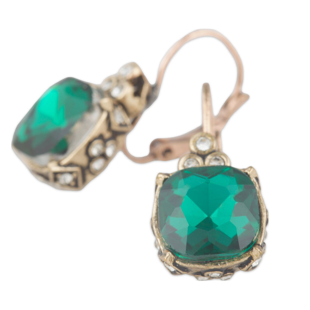 Pair of earrings with green gemstones and gold accents on a white background