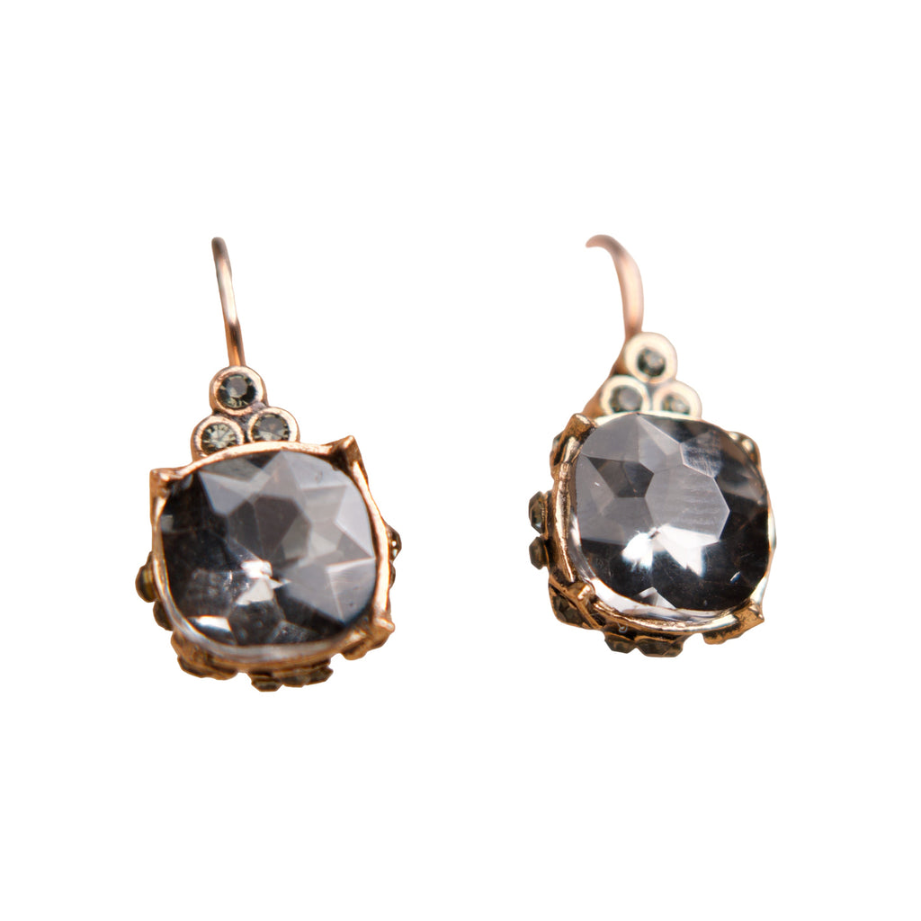 Pair of earrings with dark gemstones and rose gold accents on a white background
