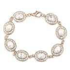 Rose gold bracelet with clear gemstones on a white background
